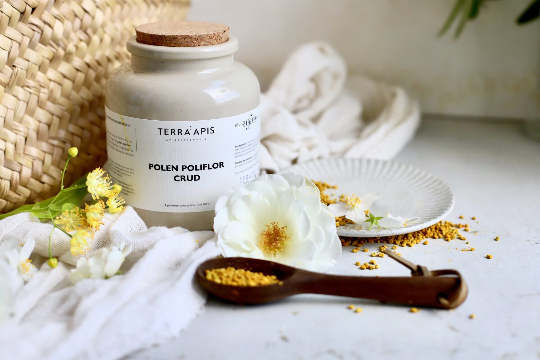 Polen crud poliflor Apiarium prezentat în recipient, granule naturale în nuanțe galbene și portocalii.